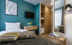 モスクワにあるHotel Tripsの青い壁のベッドルーム(ベッド1台、鏡付)