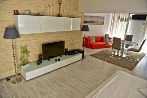 een woonkamer met een televisie en een open haard bij Eric Apartment 100 in Boekarest