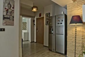 een keuken met een koelkast en een lamp en een hal bij Eric Apartment 100 in Boekarest