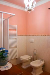 a bathroom with a toilet and a sink and a chandelier at Podere Marcigliano in Cortona