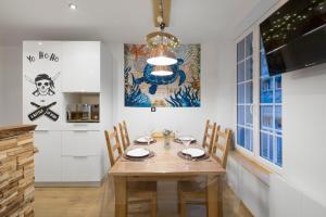 a dining room with a wooden table and chairs at La Cordee by Cocoonr in Saint Malo