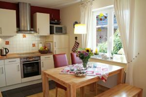 a kitchen with a table with a vase of flowers on it at Ferienwohnung Robben Deele in Sankt Peter-Ording