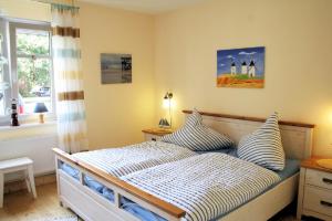 - une chambre avec un lit doté d'oreillers et d'une fenêtre dans l'établissement Ferienwohnung Robben Deele, à Sankt Peter-Ording