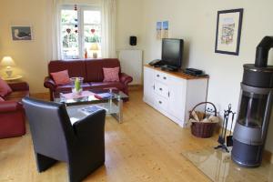 a living room with a couch and a fireplace at Ferienwohnung Robben Deele in Sankt Peter-Ording