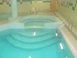 a large swimming pool with stairs in a building at Hotel Villa Plinia in Pragelato