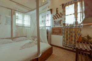 Un dormitorio con dos camas y una ventana. en Malindi Guest House, en Zanzíbar