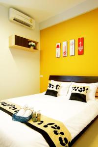 a bedroom with a large bed with black and white pillows at Smile Inn in Bangkok