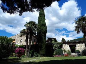 una casa con un gran árbol en un patio en Chambres d'hôtes La Chabrière, en Cliousclat