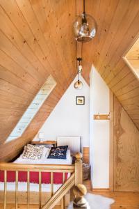 a bed in a room with a wooden ceiling at Apartament Olczanka Zakopane in Zakopane +10 photos
