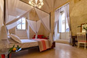 1 dormitorio con cama con dosel y lámpara de araña en Palazzo Cariddi, en Nardò