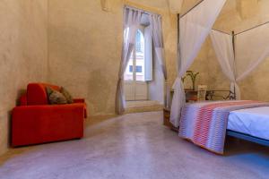1 dormitorio con 1 cama, 1 silla y 1 ventana en Palazzo Cariddi, en Nardò