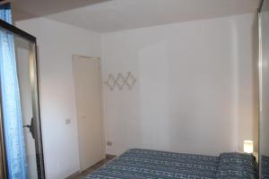 a bedroom with a bed and a mirror and a door at Cala Gavetta 5 in La Maddalena