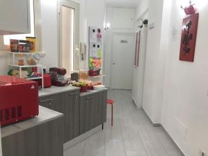 una cucina con armadi grigi e un apparecchio rosso di Dunant House a Roma