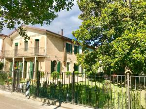 uma casa velha com uma cerca em frente em Maison Elena em Mirano