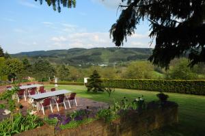 a table and chairs in a garden with a view at Apartment " Welwerwoltz " in Wilwerwiltz