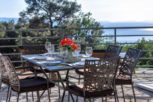 a table with chairs and wine glasses on a balcony at Holiday home Sergio in Bast
