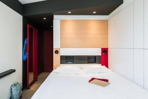 a bedroom with a white bed with a wooden headboard at ibis Budget Knokke in Knokke-Heist +21 photos