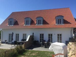 a white house with a red roof at Hof Vilmnitz Haus B in Putbus