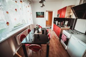 a kitchen with red cabinets and a table and a stove at Vorutos Terasa in Anykščiai