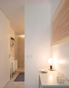 a white room with a table with a lamp on it at LUXURY ALVOR PENTHOUSE in Alvor +15 photos