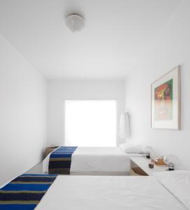 - une chambre blanche avec un lit et une fenêtre dans l'établissement LUXURY ALVOR PENTHOUSE, à Alvor