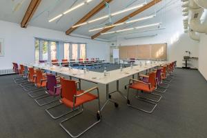 een grote vergaderzaal met een lange tafel en stoelen bij Wilhelm-Kempf-Haus in Wiesbaden