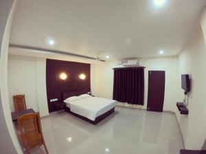 a bedroom with a bed and a television in it at Town Hub in Valāncheri