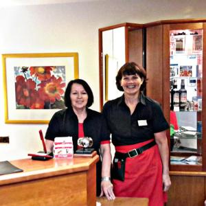 two women standing in front of a counter at Hotel Schmidt am Markt in Meppen