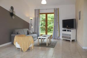 a living room with a couch and a tv at Pégase in Fa
