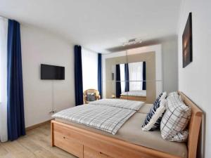 ein Schlafzimmer mit einem großen Bett und einem Spiegel in der Unterkunft VillaStrandEins Fewo Stella in Rerik
