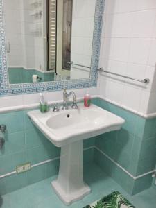 W łazience znajduje się biała umywalka i lustro. w obiekcie mela__bii w mieście Sulmona