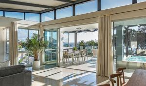 a living room with a balcony and a dining room table at Blue Views Villas and Apartments in Cape Town