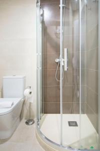 y baño con ducha y puerta de cristal. en Cruz Apartment, en Madrid