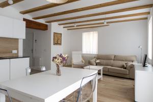 cocina blanca y sala de estar con mesa blanca en ApartUP L' Almoina, en Valencia