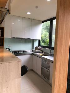 a kitchen with white cabinets and a sink and a window at Ming Yueju in Guoxing