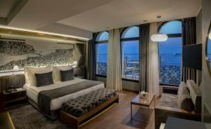ein Schlafzimmer mit einem großen Bett und großen Fenstern in der Unterkunft The Wings Hotel Istanbul in Istanbul