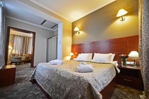 a hotel room with a bed with two towels on it at Hotel Astoria Tbilisi in Tbilisi City