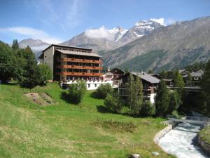 a building on a hill with mountains in the background at Hotel Bristol in Saas-Fee