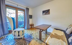 a living room with a table and a chair at Appartement Comfy in Saalbach Hinterglemm