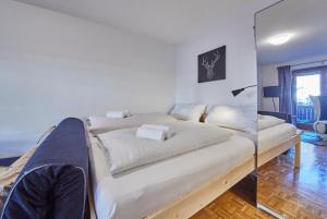 Cette chambre comprend un grand lit blanc. dans l'établissement Appartement Comfy, à Saalbach-Hinterglemm