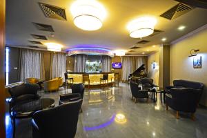 a lobby with a waiting room with chairs and a piano at Hotel Astoria Tbilisi in Tbilisi City