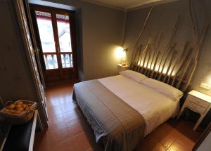 een slaapkamer met een groot bed en een raam bij Posada Rural Bistruey in Potes