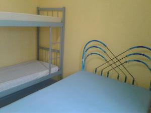 a room with two bunk beds with blue rails at Casa Praia Grande - Vila Caiçara in Solemar