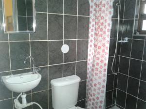 a bathroom with a toilet and a sink at Casa Praia Grande - Vila Caiçara in Solemar