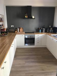 a kitchen with white cabinets and a black oven at Villa Ponte Vista in Castro Marim