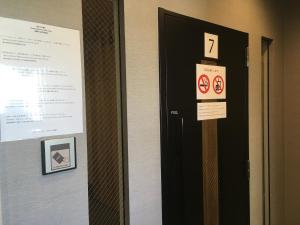 a door with signs on it next to a wall at Namba Guesthouse HIVE in Osaka