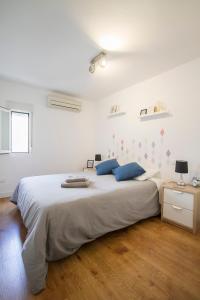 マドリードにあるCálido y acogedor en el corazón de Madridの白いベッドルーム(青い枕の大型ベッド付)