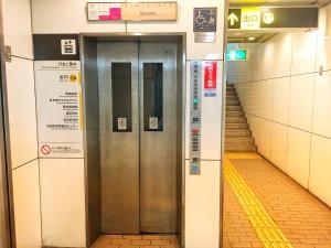 two elevator doors in a subway station with stairs at Namba Guesthouse HIVE in Osaka