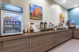 a coffee shop with a counter with a refrigerator at Sleep Inn & Suites Monroe - Woodbury in Monroe