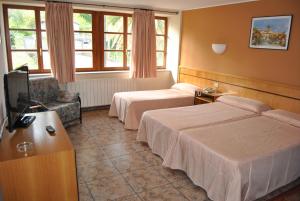 a hotel room with two beds and a television at Hotel Palacio de los Vallados in Lastres